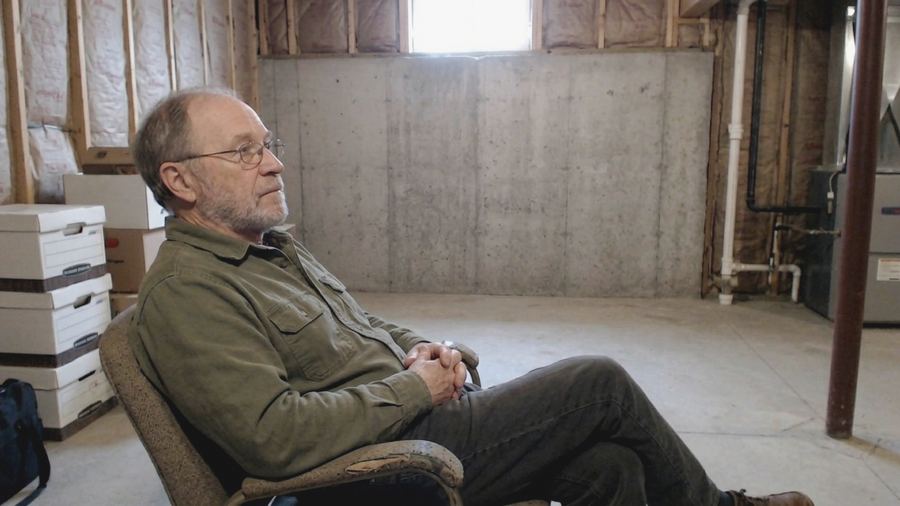 Tom Bennett looking at a basement wall